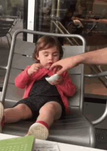 Toddler shaking their head no while holding a snack
